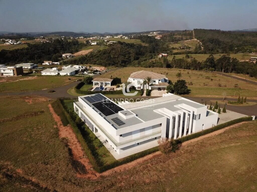 Vista aérea de casa de luxo em condomínio fechado de Itu, com arquitetura moderna e amplo terreno ao redor.