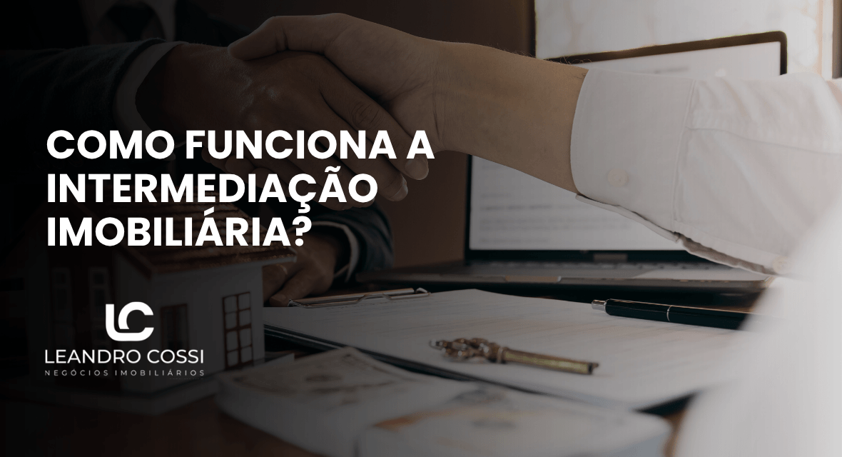 Capa do artigo sobre como funciona a intermediação imobiliária com aperto de mãos e documentos sobre a mesa.