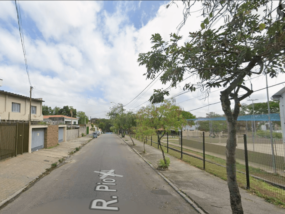 Rua residencial arborizada com calçadas, casas e área esportiva ao lado, representando o clima tranquilo de cidades do interior de SP onde ir.