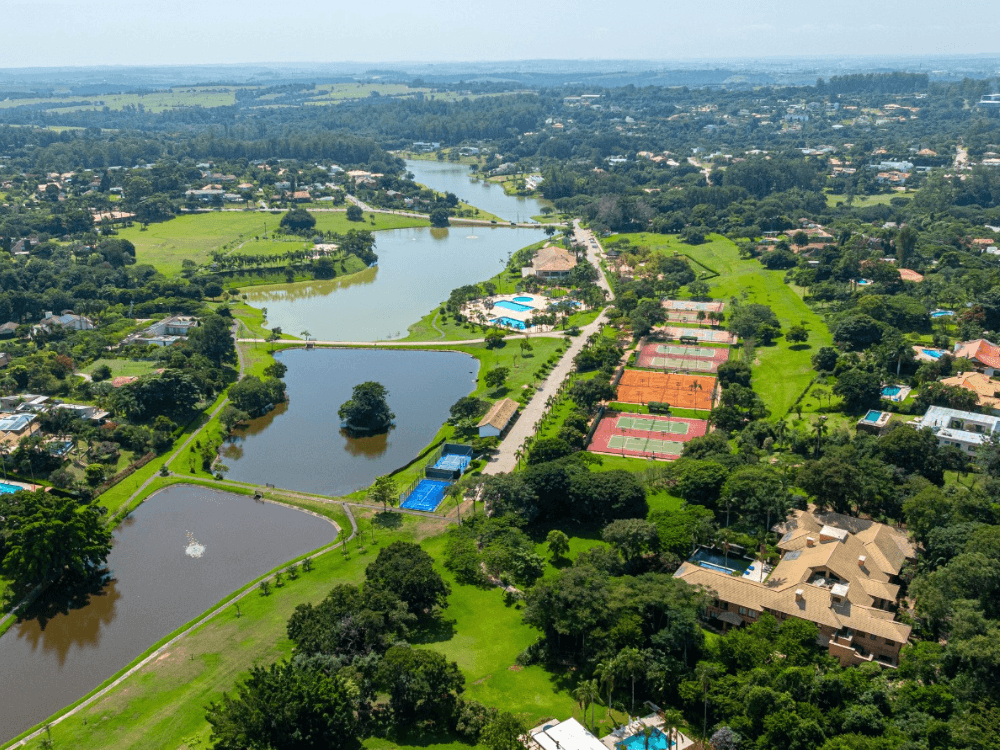 Condomínio de luxo visto do alto, com lagos, jardins, piscinas e diferentes espaços destinados ao lazer residencial